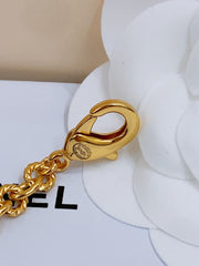 TWISTED CHAIN BELT WITH RHINESTONES AND LOGO PLATE IN GOLD TONE