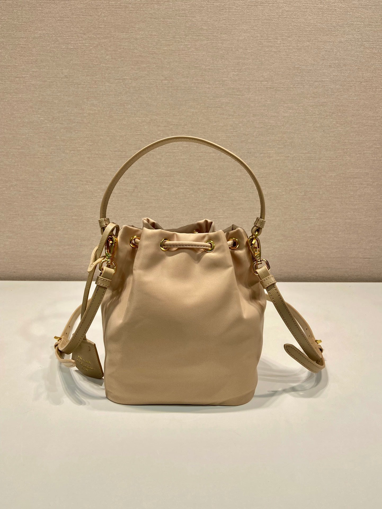 BUCKET BAG 19 IN BEIGE RE-NYLON AND SAFFIANO LEATHER HANDLE