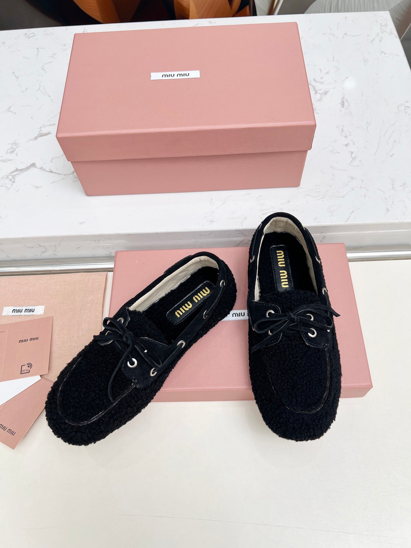 MIUMIU 26S BOAT LOAFERS IN BLACK SHEARLING