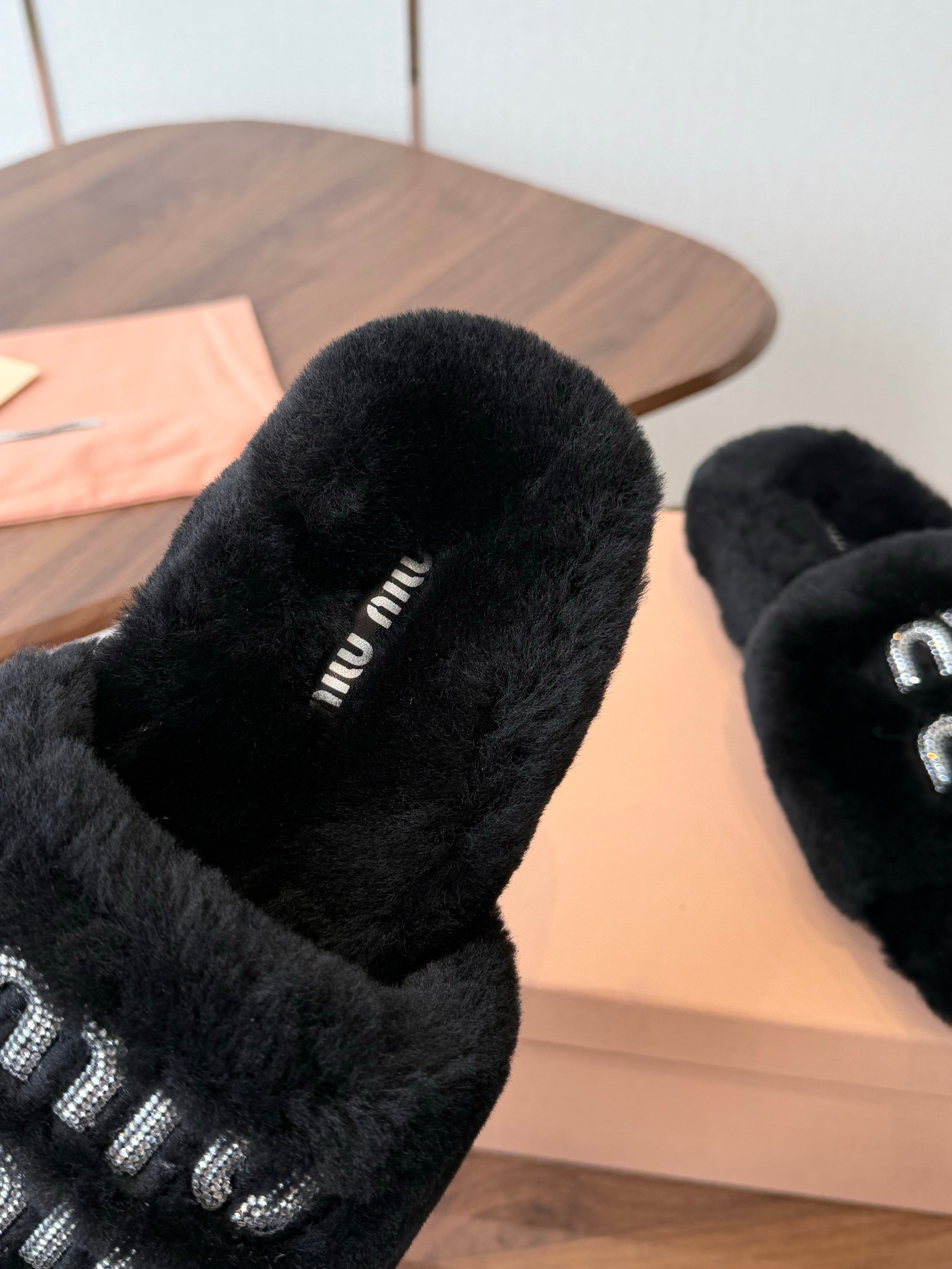MIUMIU 26S CRYSTAL LOGO SLIDES IN BLACK SHEARLING