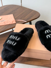 MIUMIU 26S CRYSTAL LOGO SLIDES IN BLACK SHEARLING