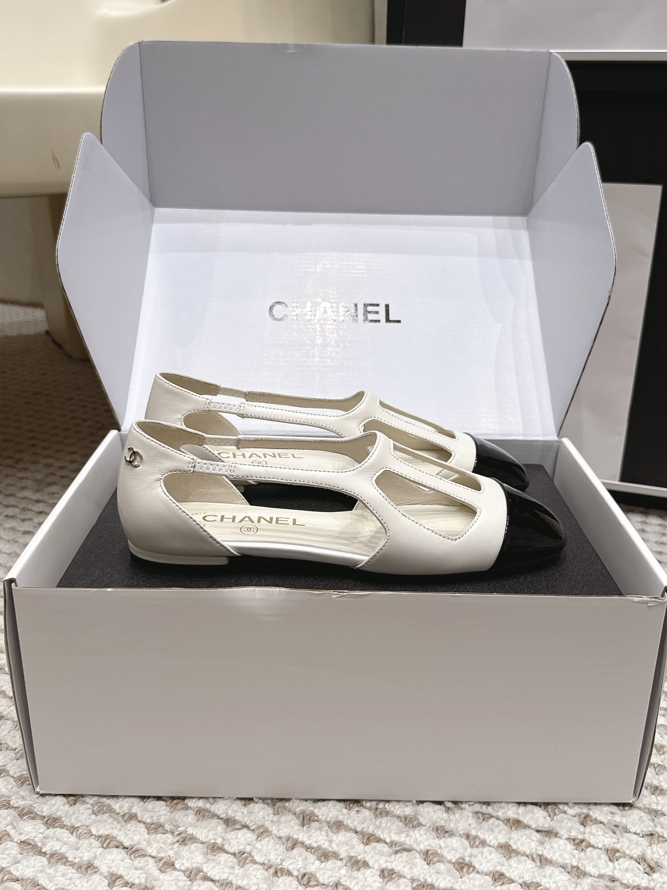 CHANEL 26S ROUND TOE MARY JANE FLATS IN OFF WHITE CUTOUT CALFSKIN WITH BLACK PATENT TOE