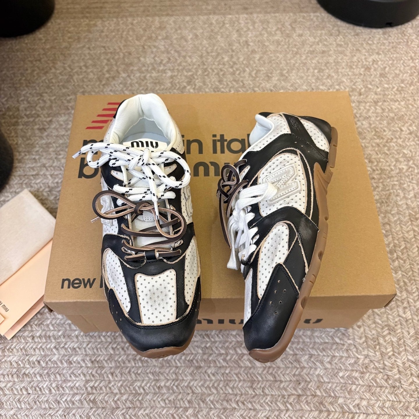 MIUMIU 26S PERFORATED SNEAKERS IN WHITE AND BLACK CALFSKIN