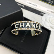 CHANEL 26S CHANEL LOGO BLACK ENAMEL STATEMENT CUFF BRACELET IN GOLD METAL 630834